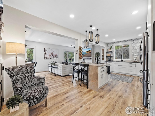 370 Big Boulder Dr, Estes Park, CO 80517 - kitchen with open floor plan, light wood-style flooring, a kitchen breakfast bar, a sink, and recessed lighting