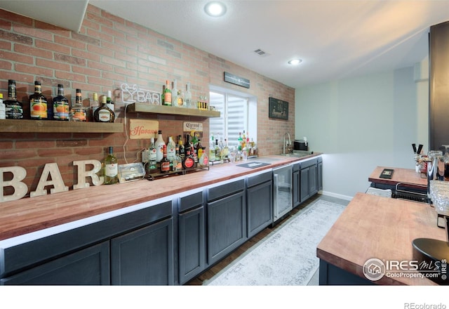 489 Hayloft Way, Brighton, CO 80601 - indoor dry bar with beverage cooler, recessed lighting, baseboards, and brick wall
