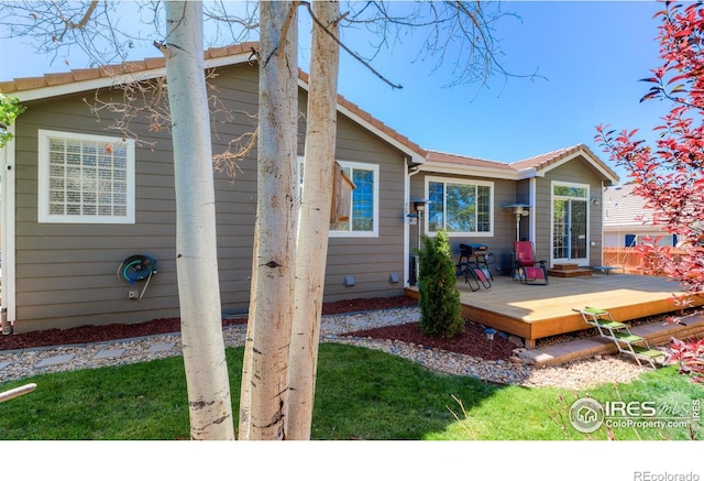 489 Hayloft Way, Brighton, CO 80601 - back of property featuring a deck and a tile roof