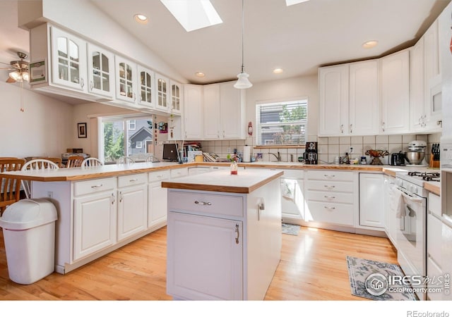 10007 E County Line Rd, Longmont, CO 80501 - kitchen with white range with gas cooktop, a kitchen island, a peninsula, backsplash, and recessed lighting
