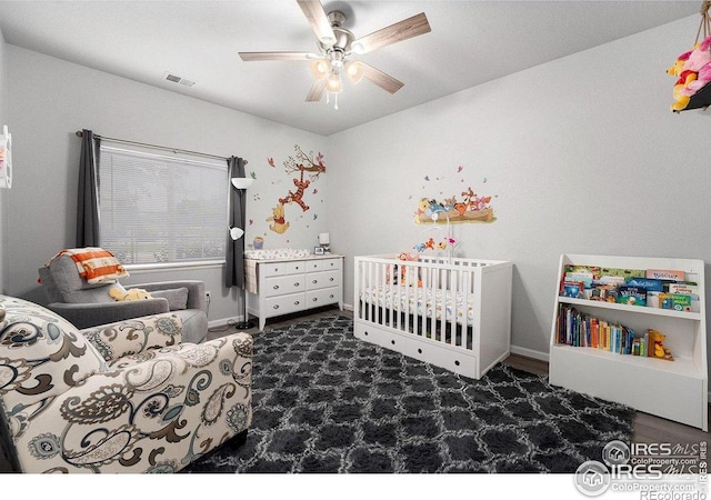 bedroom featuring a ceiling fan, baseboards, a nursery area, and carpet