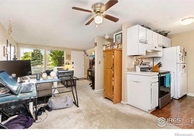 2709 Harvard St Unit 3, Fort Collins, CO 80525 - kitchen with stainless steel electric range, under cabinet range hood, a desk, a ceiling fan, and white cabinetry