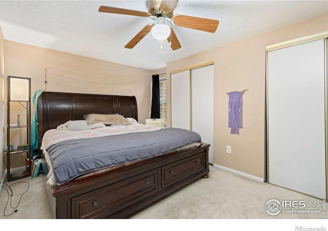 2709 Harvard St Unit 3, Fort Collins, CO 80525 - bedroom with light carpet, multiple closets, baseboards, a ceiling fan, and a textured ceiling