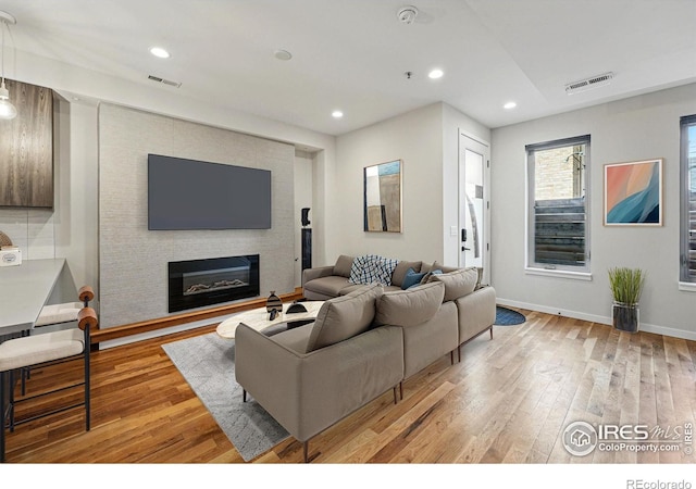 2625 W 25th Ave Unit 7, Denver, CO 80211 - living area featuring light wood-type flooring, a glass covered fireplace, recessed lighting, and baseboards
