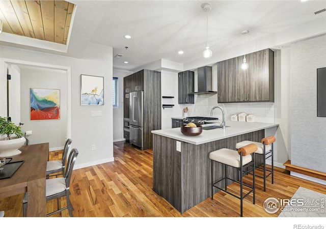 2625 W 25th Ave Unit 7, Denver, CO 80211 - kitchen featuring wall chimney exhaust hood, a breakfast bar area, high quality fridge, a peninsula, and modern cabinets