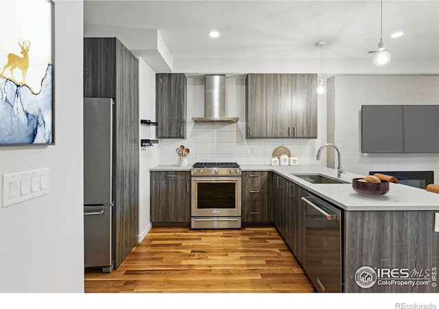 2625 W 25th Ave Unit 7, Denver, CO 80211 - kitchen with stainless steel appliances, wall chimney exhaust hood, a sink, wood finished floors, and light countertops