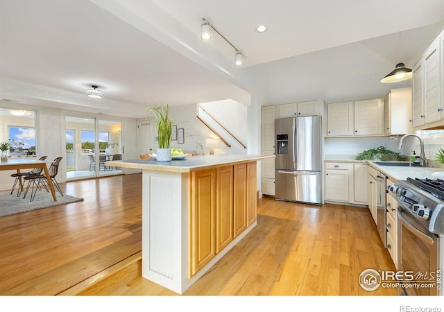 10481 Oxford Rd, Longmont, CO 80504 - kitchen with appliances with stainless steel finishes, a sink, light countertops, light wood-style flooring, and a kitchen island