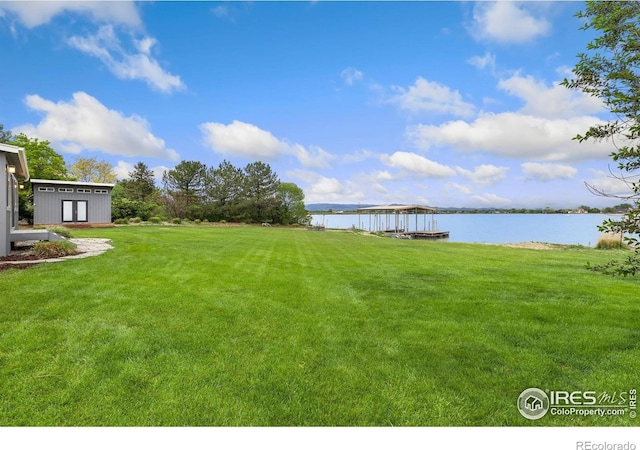 10481 Oxford Rd, Longmont, CO 80504 - view of green lawn with a water view and an outbuilding