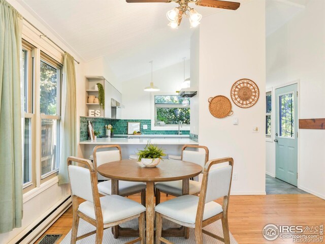 821 Hayden Ct, Longmont, CO 80503 - dining space with a baseboard radiator, healthy amount of natural light, light wood-type flooring, and vaulted ceiling