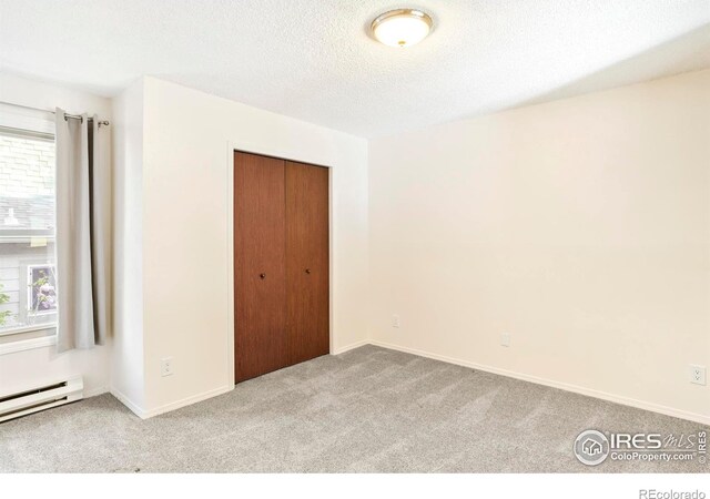 821 Hayden Ct, Longmont, CO 80503 - spare room featuring healthy amount of natural light, carpet floors, a baseboard radiator, a textured ceiling, and baseboards