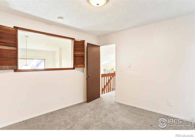 821 Hayden Ct, Longmont, CO 80503 - empty room with carpet, a textured ceiling, baseboards, and a smoke detector