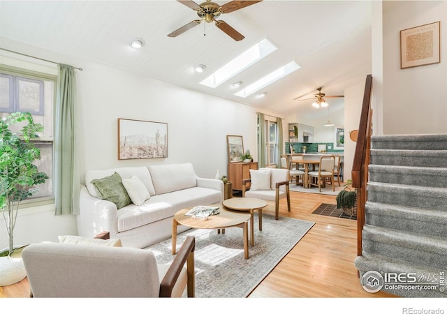 821 Hayden Ct, Longmont, CO 80503 - living room with a ceiling fan, a skylight, stairway, light wood-type flooring, and high vaulted ceiling
