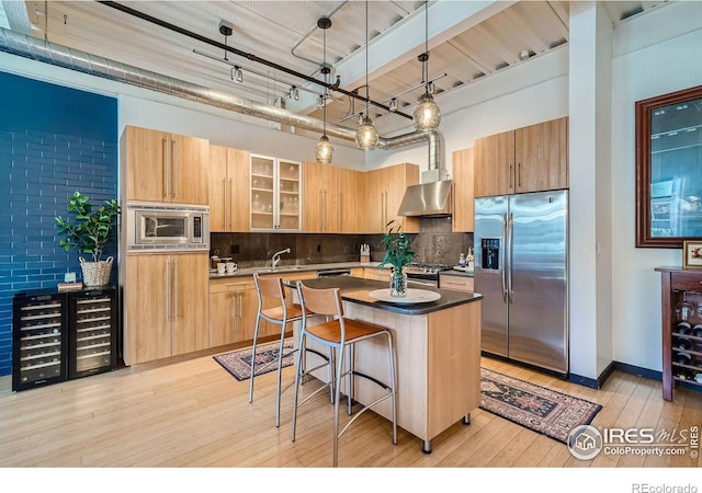 1360 Walnut St Unit 202, Boulder, CO 80302 - kitchen featuring appliances with stainless steel finishes, light wood-type flooring, decorative backsplash, a breakfast bar area, and a kitchen island