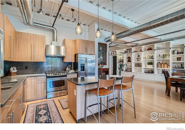 1360 Walnut St Unit 202, Boulder, CO 80302 - kitchen with stainless steel appliances, light wood-style floors, a kitchen bar, backsplash, and a kitchen island