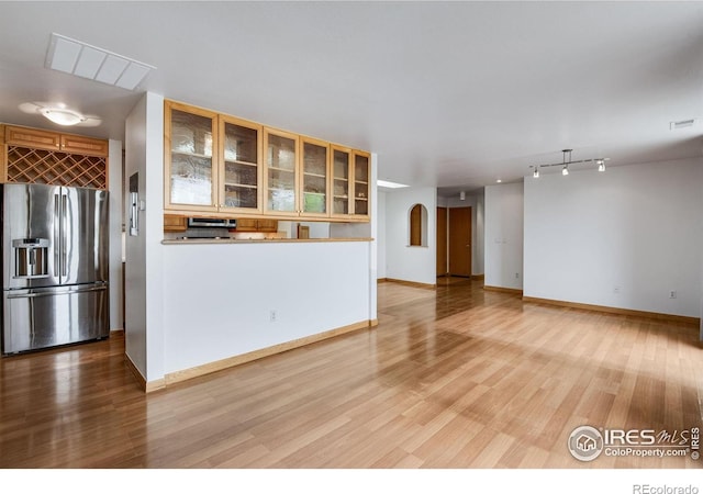 unfurnished living room featuring wood finished floors and baseboards