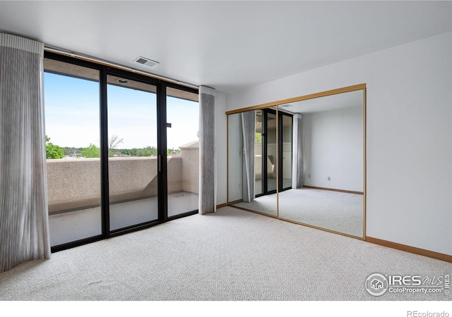 unfurnished room featuring carpet floors and baseboards