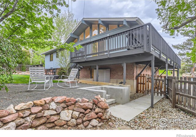 3410 Heidelberg Dr, Boulder, CO 80305 - rear view of house with a deck, a patio area, fence, a gate, and brick siding