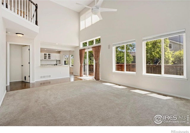 3227 Honeysuckle Ct, Fort Collins, CO 80521 - unfurnished living room with a ceiling fan, carpet floors, plenty of natural light, baseboards, and a high ceiling
