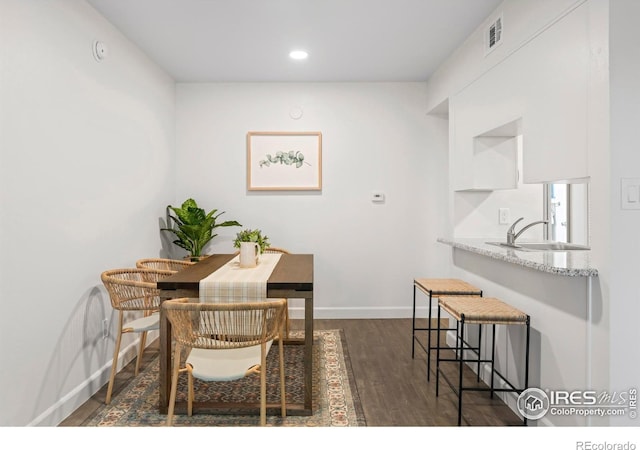 dining room with dark wood finished floors, recessed lighting, and baseboards