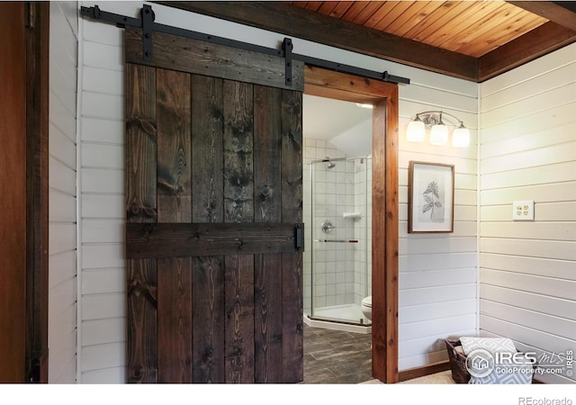 full bathroom with a shower stall, wood walls, wooden ceiling, and toilet