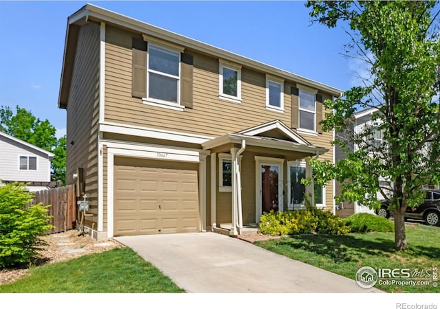 view of front of home with fence, driveway, and a garage
