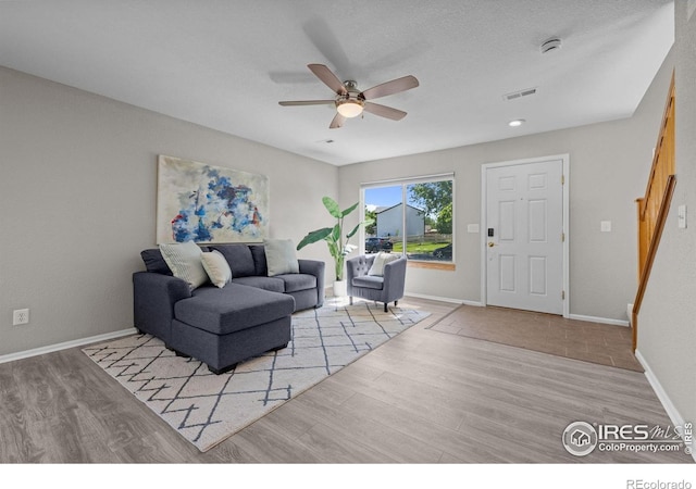 living area with wood finished floors, ceiling fan, and baseboards