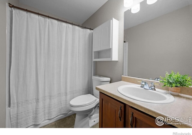 full bathroom with toilet, a textured wall, tile patterned floors, and vanity