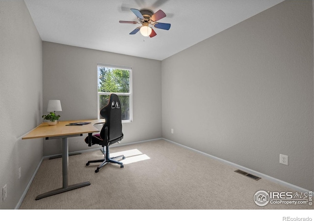 carpeted office featuring a ceiling fan and baseboards