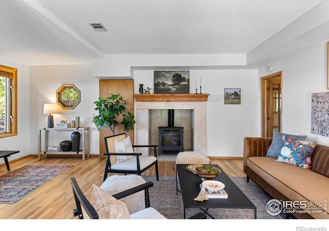 4743 Jay Rd, Boulder, CO 80301 - living room with a textured ceiling, a wood stove, wood finished floors, and baseboards