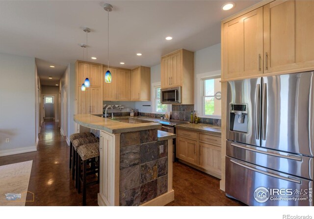 23111 County Road 1, Berthoud, CO 80513 - kitchen featuring stainless steel appliances, light brown cabinets, recessed lighting, a kitchen breakfast bar, and tasteful backsplash