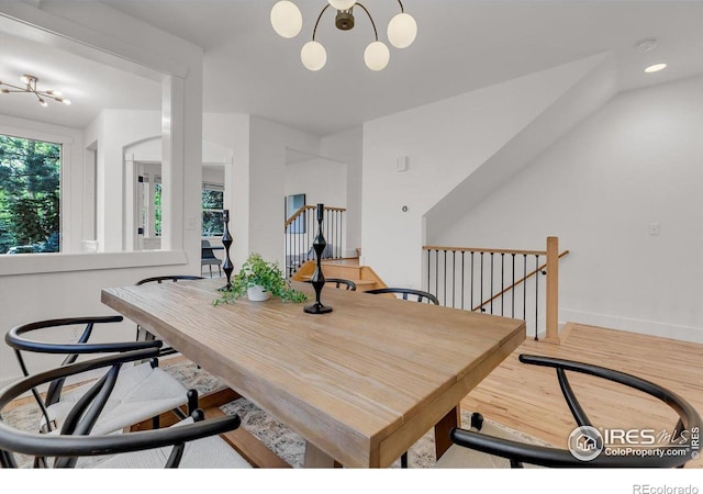 dining room with a chandelier, baseboards, and wood finished floors