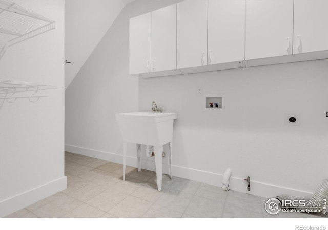 clothes washing area with cabinet space, hookup for a washing machine, and baseboards