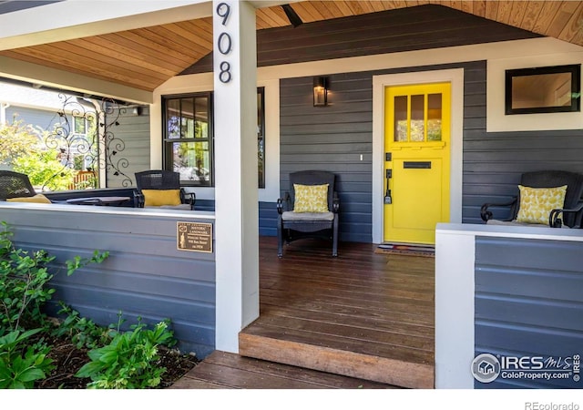 view of exterior entry featuring covered porch