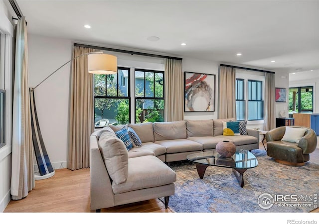 living room with light wood-type flooring and recessed lighting