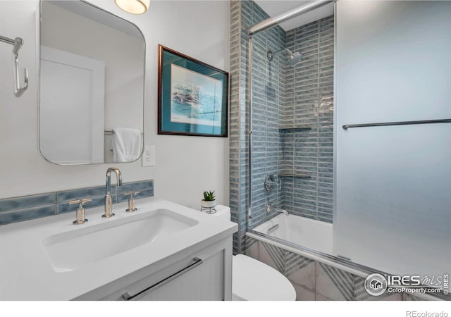 full bath featuring tiled shower / bath, toilet, and vanity