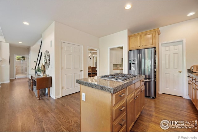 kitchen featuring stainless steel appliances, a kitchen island, wood finished floors, light brown cabinets, and recessed lighting
