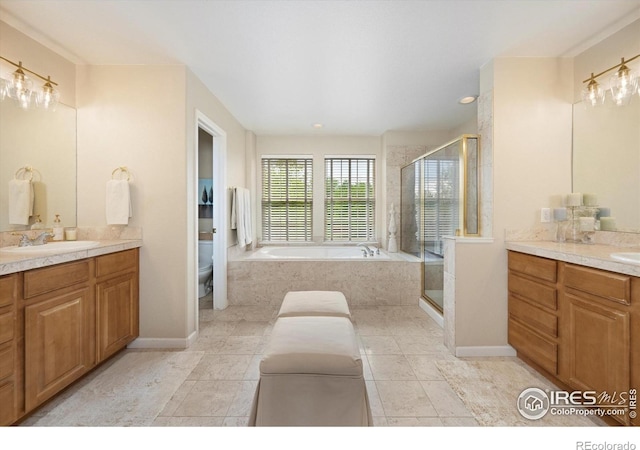 full bath featuring a shower stall, a bath, two vanities, and toilet