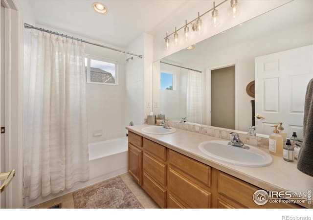 bathroom featuring shower / bath combo with shower curtain, double vanity, and tile patterned floors