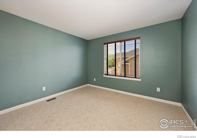 carpeted spare room with baseboards