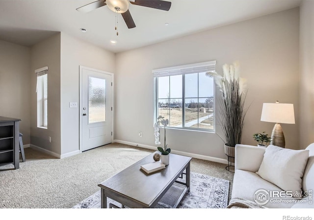 living area featuring carpet floors, a ceiling fan, and baseboards