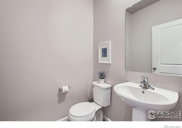 half bath with toilet and a sink