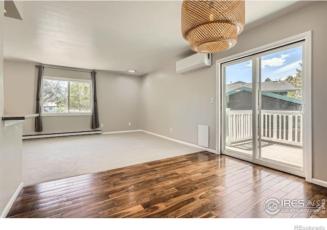 unfurnished room with baseboard heating, a wall mounted AC, hardwood / wood-style flooring, and baseboards