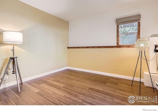 unfurnished room with wood finished floors and baseboards