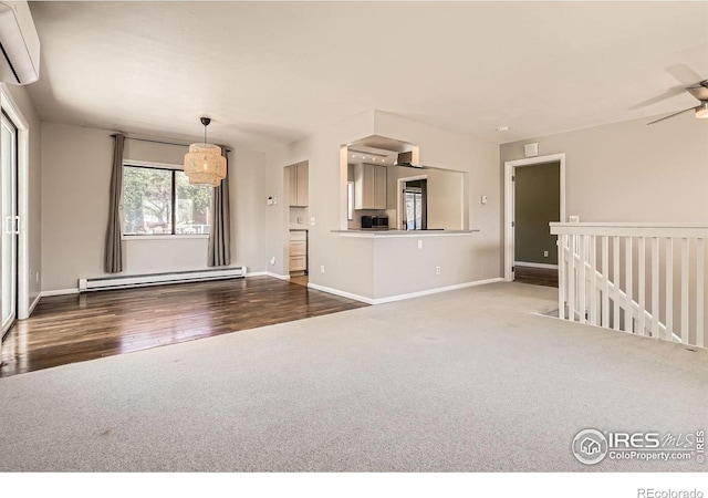 unfurnished living room with a baseboard radiator, a wall mounted AC, carpet floors, wood finished floors, and baseboards