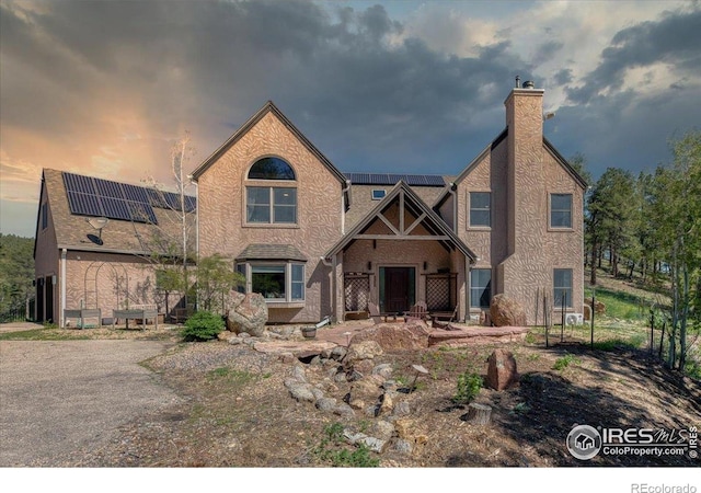 1057 Reed Ranch Rd, Boulder, CO 80302 - view of front of home featuring roof mounted solar panels and a chimney