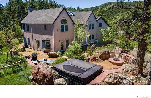 1057 Reed Ranch Rd, Boulder, CO 80302 - back of property featuring a chimney, an outdoor fire pit, stucco siding, and a mountain view