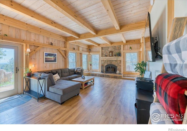 1057 Reed Ranch Rd, Boulder, CO 80302 - living room with light wood-type flooring, beam ceiling, wooden walls, and a fireplace
