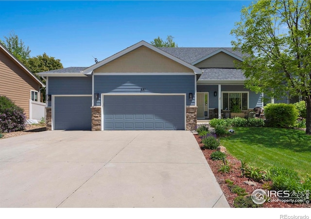 641 Yukon Ct, Windsor, CO 80550 - view of front of property with a front lawn, an attached garage, stone siding, and concrete driveway
