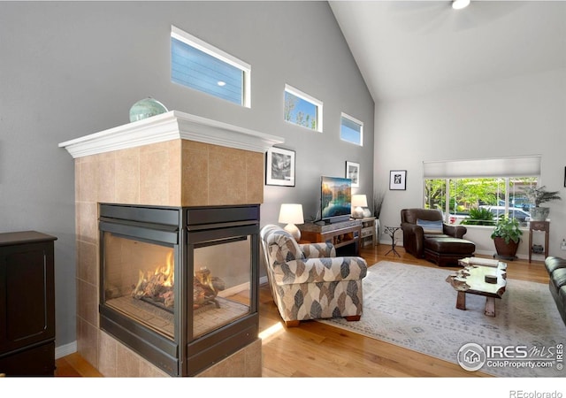 641 Yukon Ct, Windsor, CO 80550 - living area with a tiled fireplace, high vaulted ceiling, and wood finished floors