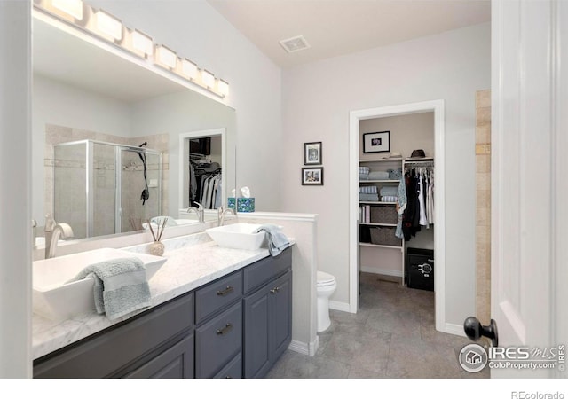 641 Yukon Ct, Windsor, CO 80550 - full bath with a stall shower, toilet, double vanity, a spacious closet, and tile patterned flooring